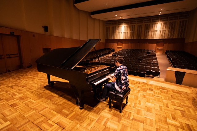 Jacob playing piano in empty auditorium
